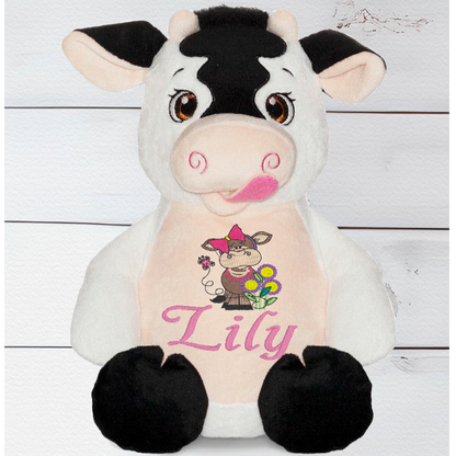 Meet Daisy the Cow Bear our cuddly teddy bear who has a white and cream body with black patterned prints, big, beautiful black eyes, small cream horns, pink, swirly nostrils, and a mouth with a tongue.